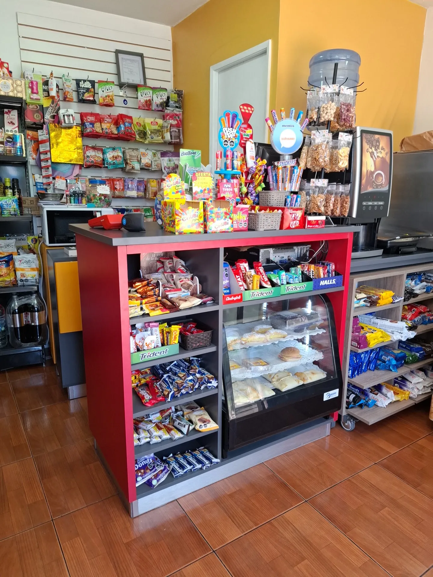 Mesón con dulces, vitrina de pasteles y máquina de café