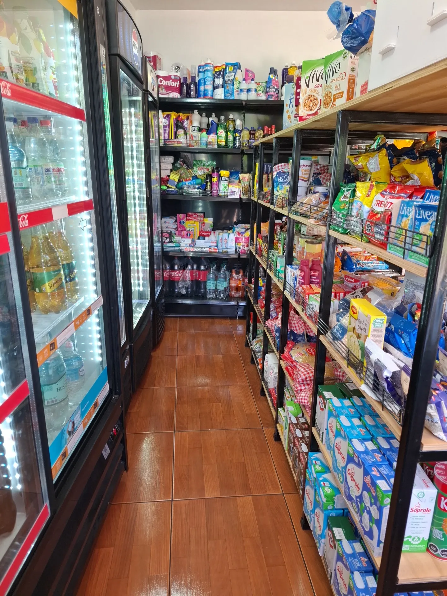 Pasillo con refrigeradores de bebidas y estantes de abarrotes